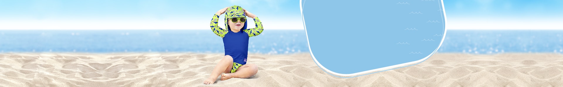 Banner della pagina consigli per il nuoto, con un bambino seduto sulla spiaggia che indossa un completo da nuoto