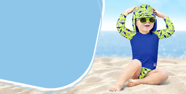 Banner della pagina consigli per il nuoto, con un bambino seduto sulla spiaggia che indossa un completo da nuoto